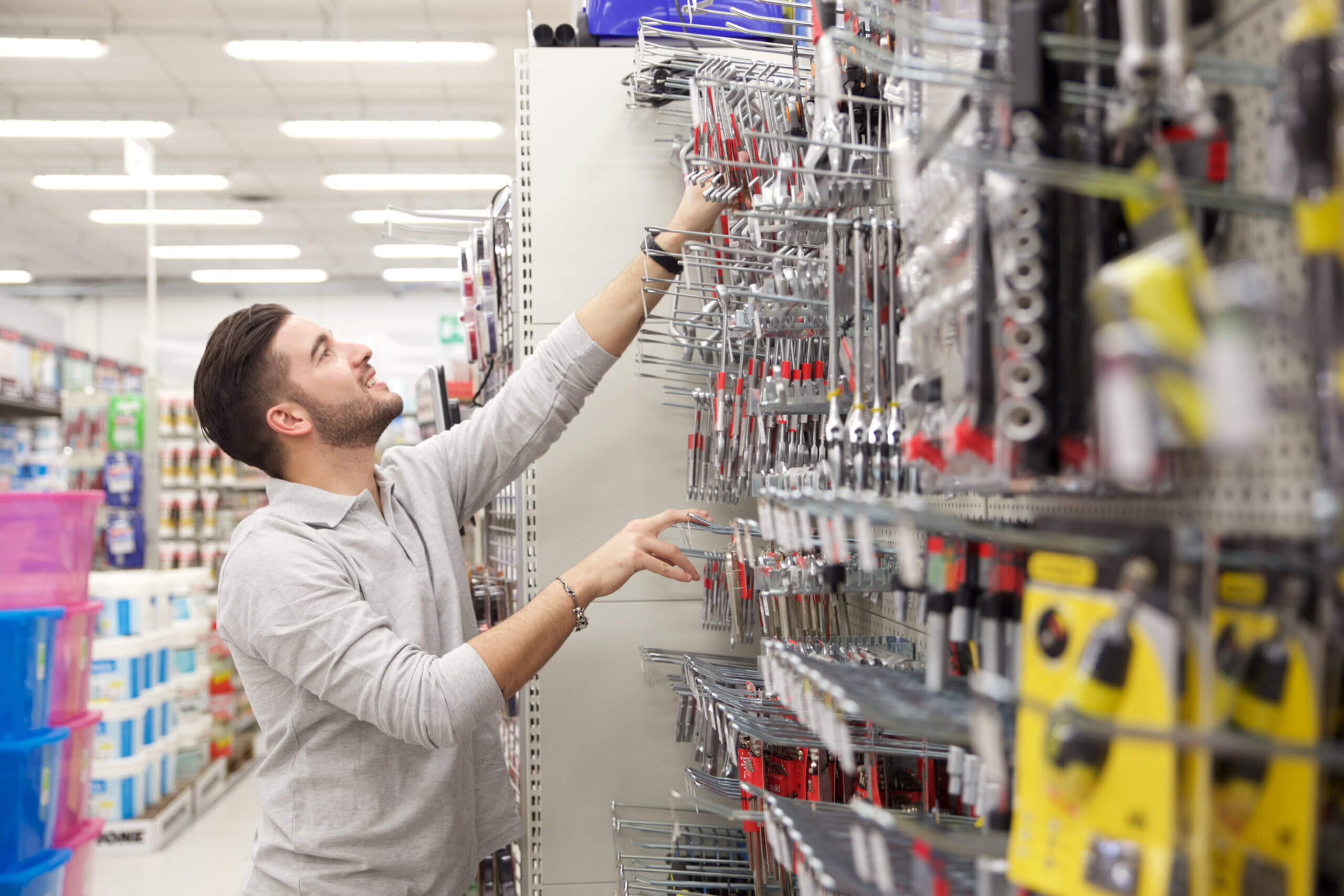A customer looking at tools on a shelf at a hardware store